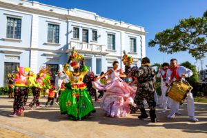 people in green and pink dress dancing on street during daytime